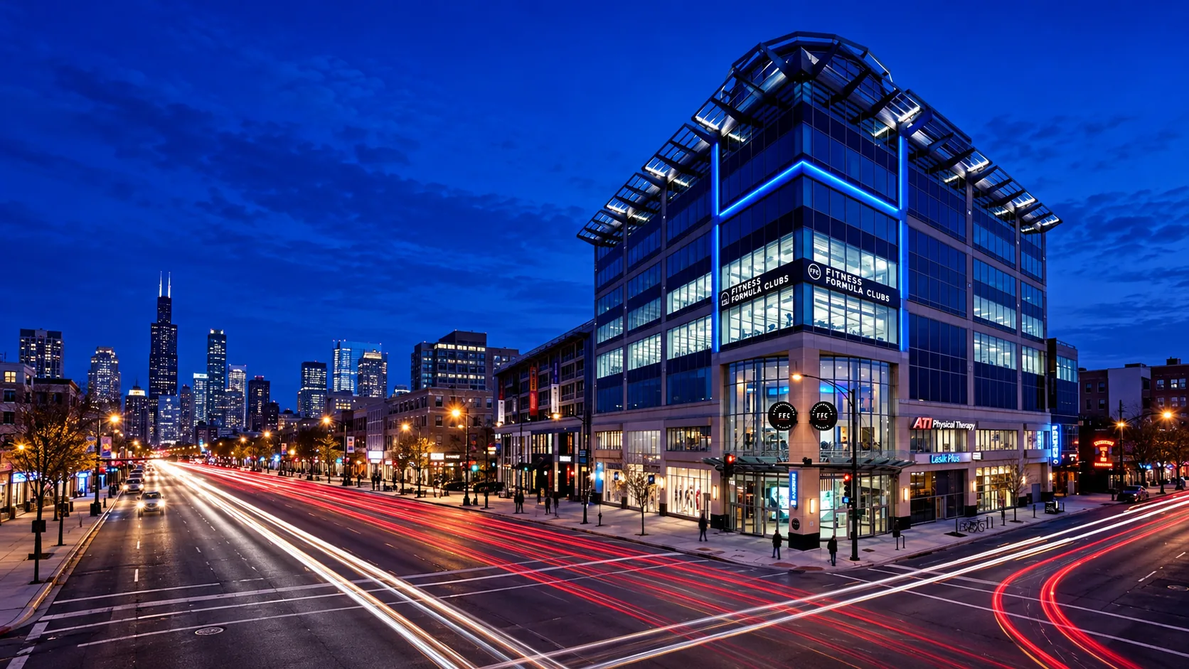 Dental Salon's Lincoln Park building at dusk: a modern glass corner building with blue accent lighting, traffic light trails along the avenue, and the Chicago skyline in the distance.